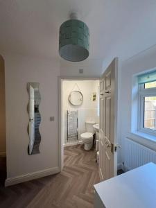 a bathroom with a toilet and a phone on the wall at Annie's Hideaway in Chapel Saint Leonards