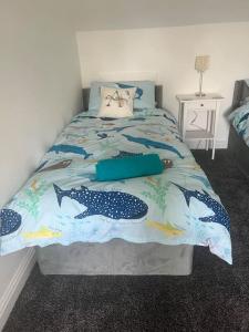 a bedroom with a bed with a fish themed bedspread at Annie's Hideaway in Chapel Saint Leonards