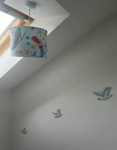 a light hanging from a ceiling with birds on it at Annie's Hideaway in Chapel Saint Leonards