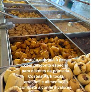 un montón de pasteles en bandejas en una panadería en RIACHI POUSADA, en Atibaia