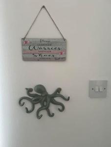 a sign hanging on a wall with an octopus on it at Annie's Hideaway in Chapel Saint Leonards