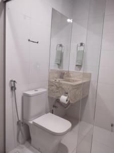 een witte badkamer met een toilet en een wastafel bij Quarto Nostalgia in Rio Branco