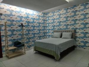 a bedroom with a bed and a wall covered in fishes at Quarto Nostalgia in Rio Branco