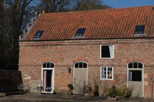 a brick house with white doors and a red roof at Country Cottage near Yorkshire Coast in Bridlington