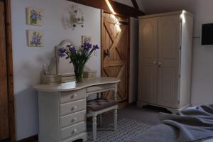 um quarto com uma cómoda com um vaso de flores em Country Cottage near Yorkshire Coast em Bridlington
