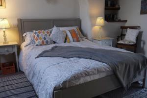 a bedroom with a large bed with two tables and two lamps at Country Cottage near Yorkshire Coast in Bridlington