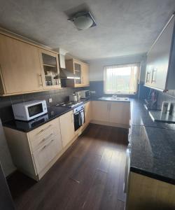a kitchen with wooden cabinets and a black counter top at Chatham Three Bedroom in Chatham
