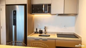 uma cozinha com um lavatório e um frigorífico em White 2880 - Pinheiros em São Paulo