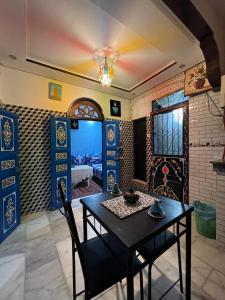 a dining room with a table and a bedroom at Dar Ghita Medina in Rabat