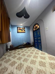 a bedroom with a large bed and a ceiling fan at Dar Ghita Medina in Rabat