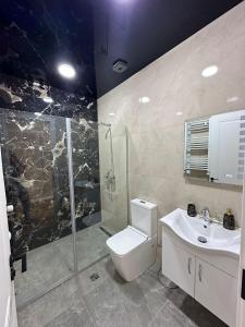 uma casa de banho com um chuveiro, um WC e um lavatório. em KIKETI 45 em Tbilisi