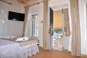 a bedroom with a bed and a view of a balcony at Elena's Island House in Poros