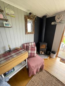 A bed or beds in a room at Oakley View Shepherds Hut with hot tub