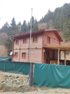 una casa de madera con una valla delante en Çat Hause Mountain en Çamlıhemşin
