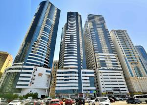 een groep hoge gebouwen in een stad met auto's bij Deluxe Rooms in Al Mamzar SHJ Shared bathroom in Sharjah