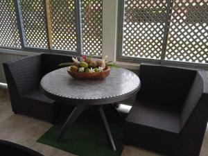 a table with a bowl of fruit on it next to two chairs at Chez Angele in Faie +4 photos