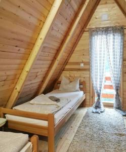 a bedroom in a log cabin with a bed at Konak kod Tose in Banja Luka