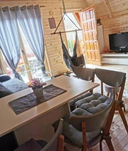 Konak kod Tose في بانيا لوكا: غرفة معيشة مع طاولة وكراسي في كابينة