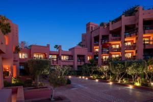 a large pink building with trees in front of it at The Ritz-Carlton Tenerife, Abama in Guía de Isora