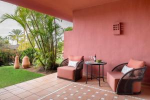 a patio with two chairs and a table and grass at The Ritz-Carlton Tenerife, Abama in Guía de Isora
