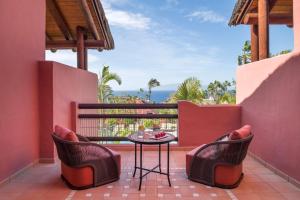 a patio with a table and chairs on a balcony at The Ritz-Carlton Tenerife, Abama in Guía de Isora
