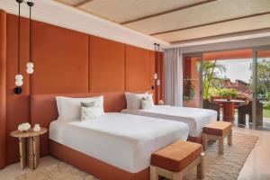 a hotel room with two beds and a balcony at The Ritz-Carlton Tenerife, Abama in Guía de Isora