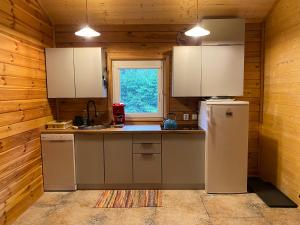 a kitchen with white cabinets and a refrigerator at Sosenkowe Zacisze in Ciche