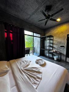 a bedroom with a white bed with a ceiling fan at The Mureed in Fulidhoo