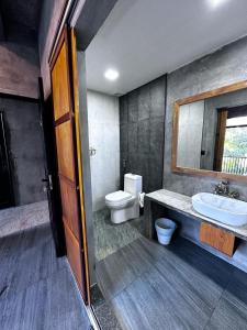 a bathroom with a toilet and a sink and a mirror at The Mureed in Fulidhoo