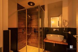 a bathroom with a glass shower and a sink at Abside Suite & Spa in Palermo