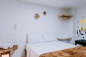 Un dormitorio con una cama y una silla verde. en Origen Hostel Jardín, en Jardín