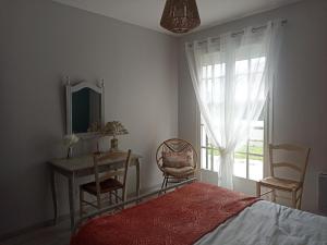 1 dormitorio con cama, mesa y ventana en Entre 2 Châteaux, en Onzain