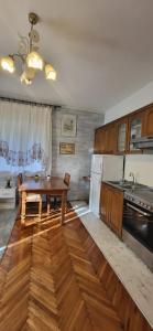 a kitchen with a wooden table and a wooden floor at Studio apartman in Meljine