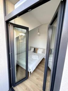 ヴィリニュスにあるBrand-new Central Loftの鏡にベッドが備わるベッドルームの反射