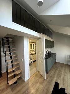 a room with a staircase and a kitchen with a kitchen at Brand-new Central Loft in Vilnius