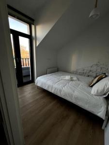 a bed in a room with a large window at Brand-new Central Loft in Vilnius