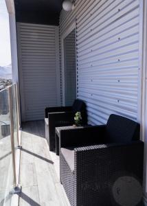 einen Balkon mit Sofas und Stühlen auf einem Gebäude in der Unterkunft Haiken Ushuaia II in Ushuaia