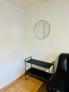 a living room with a mirror and a black chair at Knuffige Ferienwohnung im Herzen von Haiger in Haiger