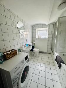 a white bathroom with a washing machine in it at Knuffige Ferienwohnung im Herzen von Haiger in Haiger