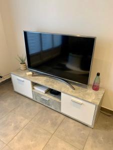 a large flat screen tv sitting on a entertainment center at Grand F3 - Emplacement d'or proche Paris et Versailles in Plaisir