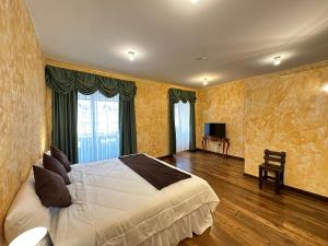 a bedroom with a large bed and a television at NASS Central Garden in Cuenca