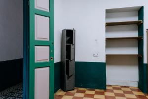 an empty room with a green door and shelves at Origen Hostel Jardín in Jardin
