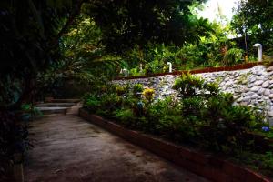 einen Garten mit Blumen und einer Steinmauer in der Unterkunft Cabañas Horeb in Tena