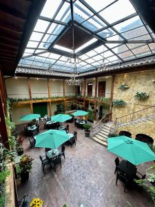 un restaurante interior con mesas y sombrillas verdes en NASS Central Garden en Cuenca