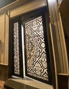 una puerta con una puerta de hierro forjado en un edificio en تربل فور سويت - شقة في فيلا, en Al Başar