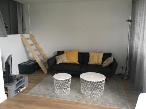 een woonkamer met een bank en 2 tafels bij Joli Duplex rénové à neuf de 72m² in Fresnes
