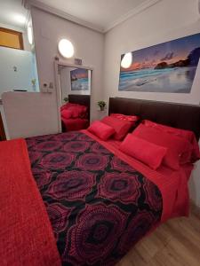 a bedroom with a large bed with red pillows at Alicante Denia Apartments in Alicante