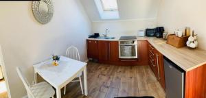 uma cozinha com uma mesa e uma mesa e cadeiras brancas em Bursztynowa komnata - apartament em Gdańsk