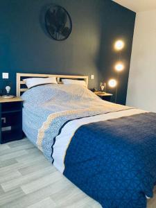 a bedroom with a bed with a blue blanket on it at Duplex au cœur de Béthune in Béthune