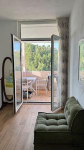 - un salon avec un canapé et une porte coulissante en verre dans l'établissement BS Apartment 5, à Durrës